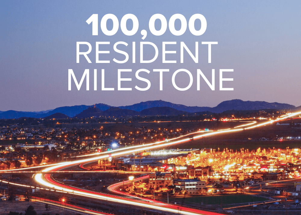 The words '100,000 Resident Milestone' overlay an aerial image of Menifee, glowing at dusk