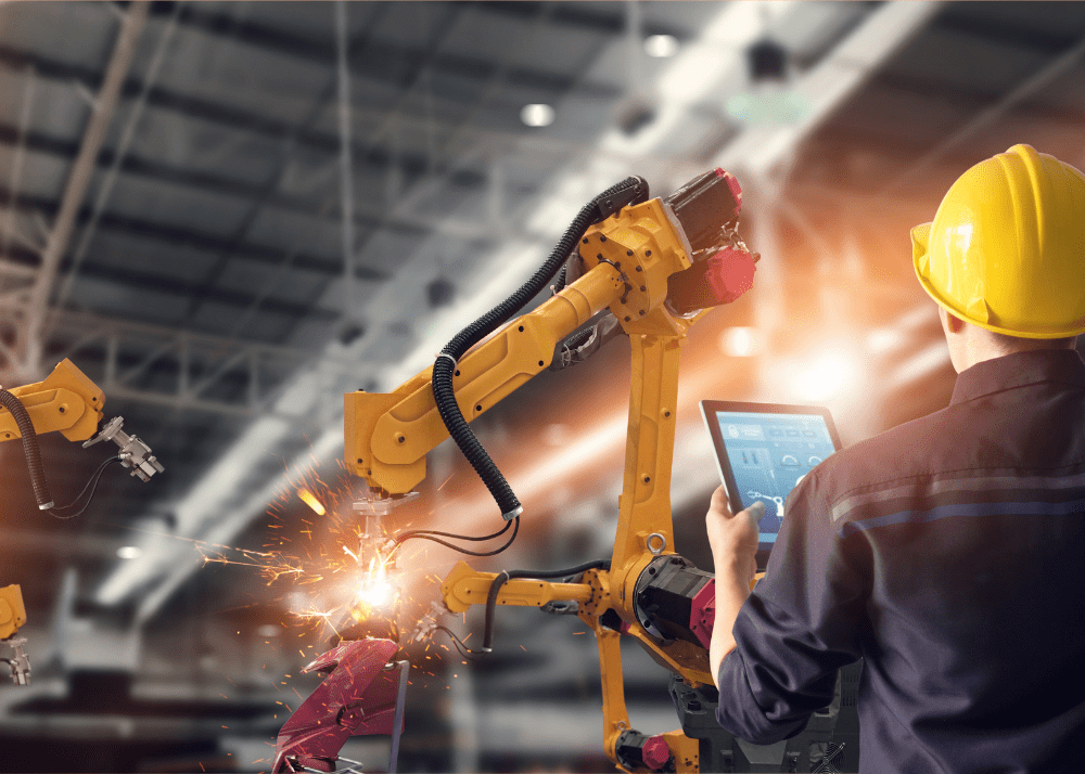 Composite Image: A worker in safety gear holding a tablet inspects a working industrial robot, backlit by sparks