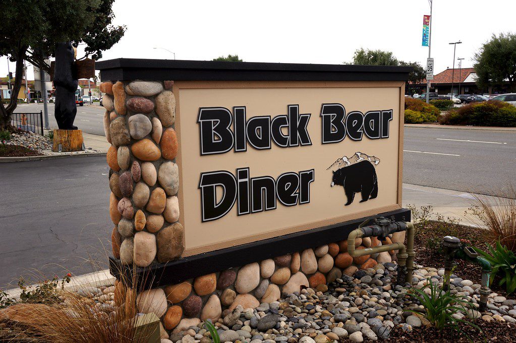 Signage for Black Bear Diner, bordered by river rock